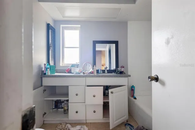 a bathroom with a granite countertop sink and a mirror