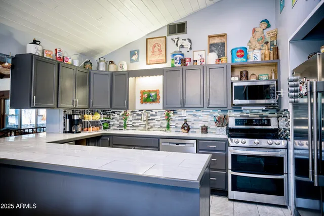 a kitchen with kitchen island a sink stainless steel appliances and cabinets