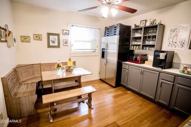 a kitchen with stainless steel appliances granite countertop a dining table chairs and a stove top oven