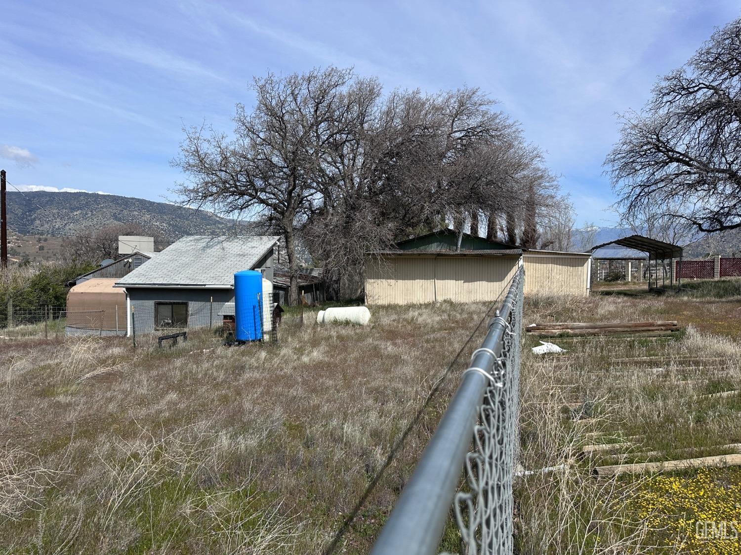 Undisclosed Address Bodfish, CA 93205 - Photo 24 of 61 Near the edge of the property, looking toward the loft, you can see the water well with the blue tank and the shop on the right.