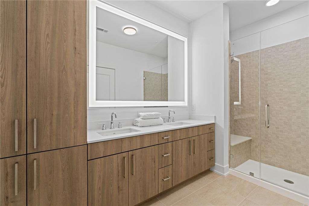 775 Juniper Street Northeast, Unit 111 Atlanta, GA 30308 - Photo 12 of 56 a bathroom with a double vanity sink and mirror