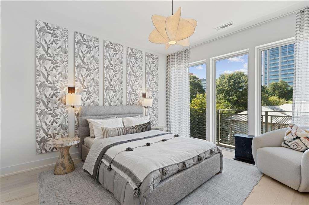 775 Juniper Street Northeast, Unit 111 Atlanta, GA 30308 - Photo 13 of 56 a bedroom with a large bed and a chandelier