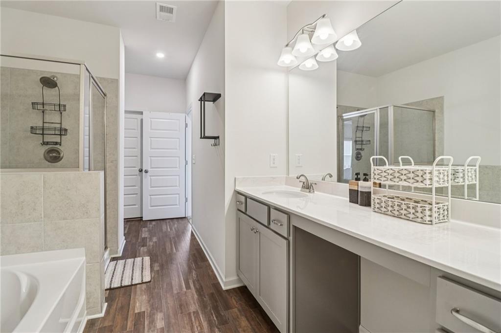 3625 Fairhaven Drive Powder Springs, GA 30127 - Photo 10 of 20 a bathroom with a double vanity sink a mirror and a bathtub