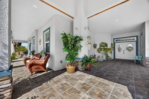 a kitchen with stainless steel appliances kitchen island granite countertop a refrigerator a stove a sink a dining table and chairs with wooden floor
