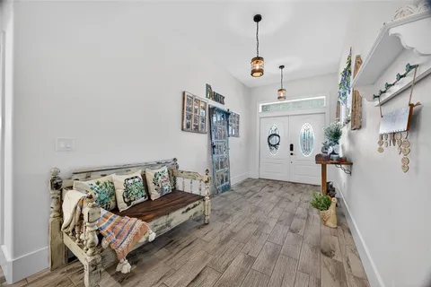 a view of a dining room and livingroom with furniture wooden floor a chandelier