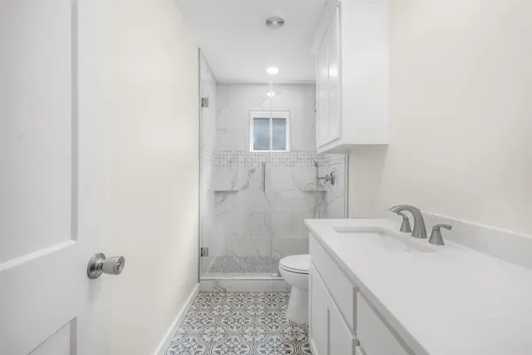 a bathroom with a sink a toilet and shower