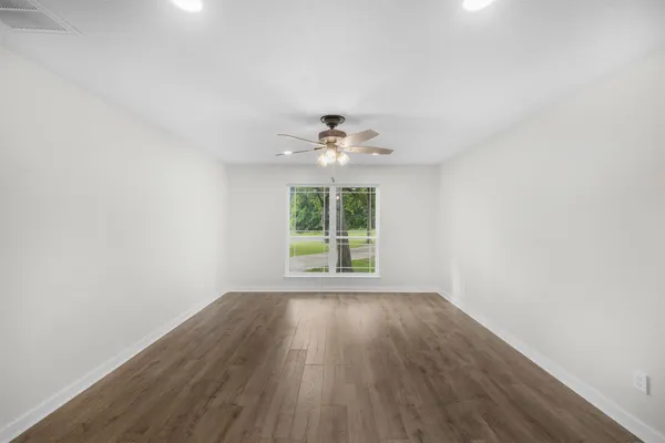 wooden floor in an empty room with a window