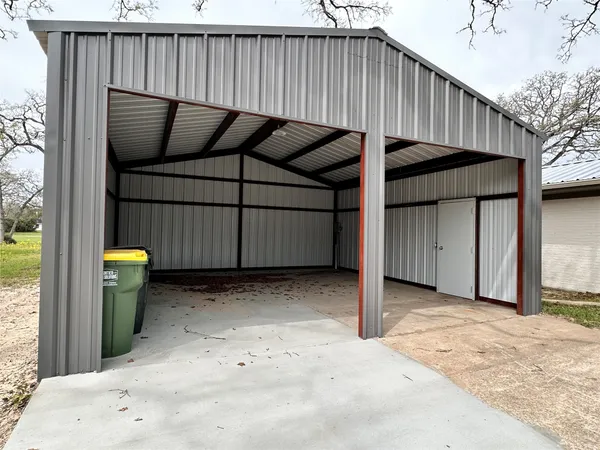 a view of a backyard with a barbeque and wooden fence