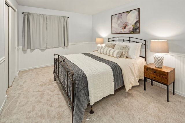 a bedroom with a bed and a painting on the wall