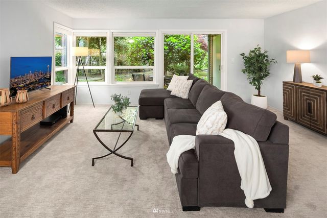 a living room with furniture a flat screen tv and a large window
