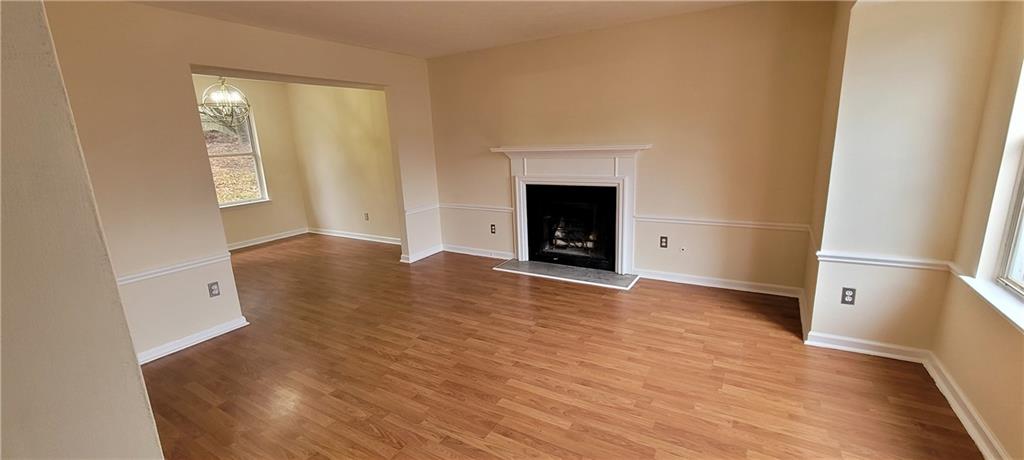 2082 Montgomery Trail Duluth, GA 30096 - Photo 5 of 31 an empty room with wooden floor and a fireplace