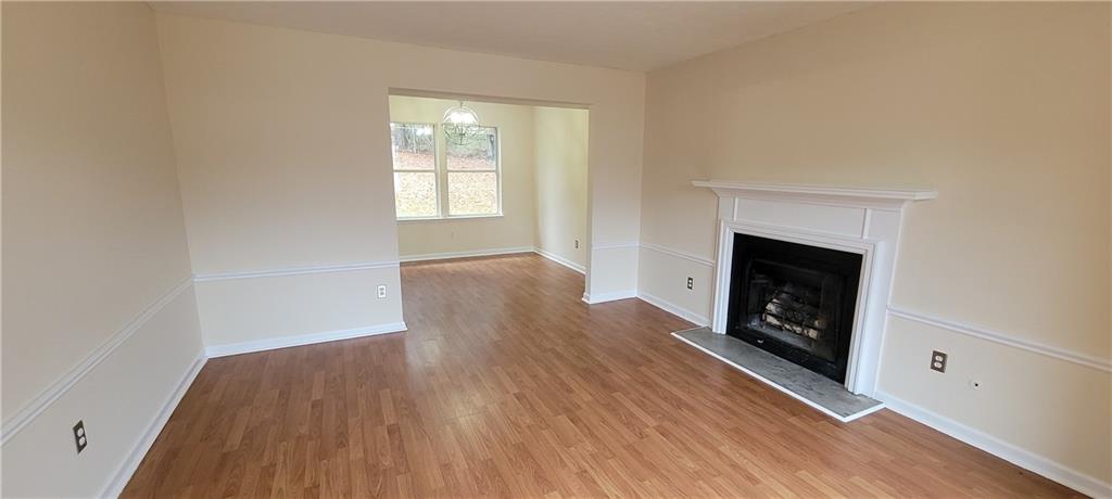 2082 Montgomery Trail Duluth, GA 30096 - Photo 7 of 31 an empty room with wooden floor fireplace and windows