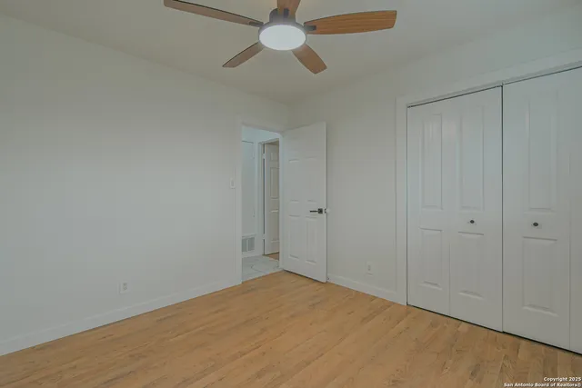 a view of a livingroom with a ceiling fan & wooden floor