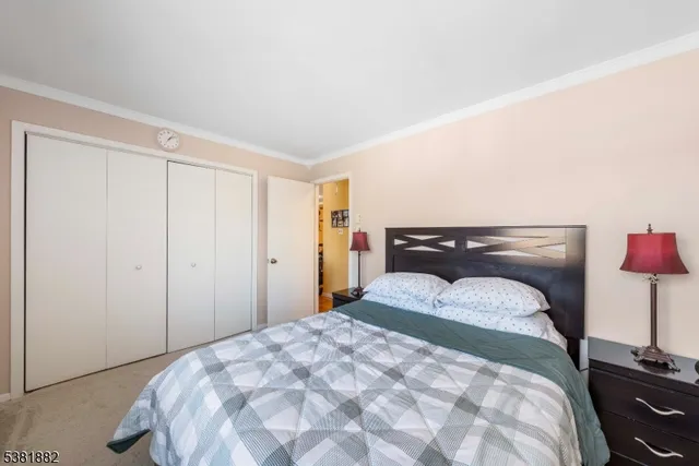 a bedroom with a bed and a lamp on dresser