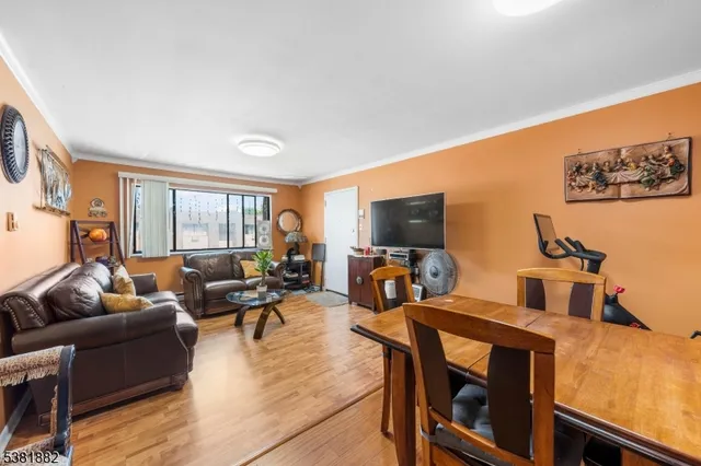 a living room with furniture a flat screen tv and a large window