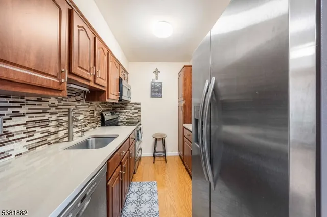 a kitchen with stainless steel appliances granite countertop a sink and a refrigerator