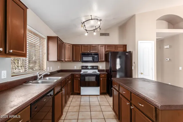 a kitchen with stainless steel appliances wooden cabinets a sink and a stove