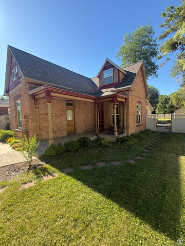 541 300 North Provo, UT 84606 - Photo 5 of 36 Brick exterior featuring a covered porch with decorative millwork, dormer windows, and a shingled roof