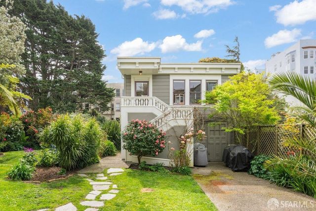 a view of a big yard with plants and large trees