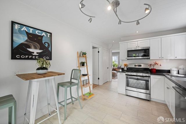 a kitchen with granite countertop a refrigerator a stove a sink a dining table and chairs with wooden floor