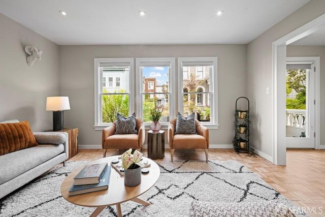 a living room with furniture kitchen view and a window