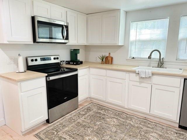 1118 East Oak Street Denton, TX 76205 - Photo 4 of 9 a kitchen with white cabinets and appliances