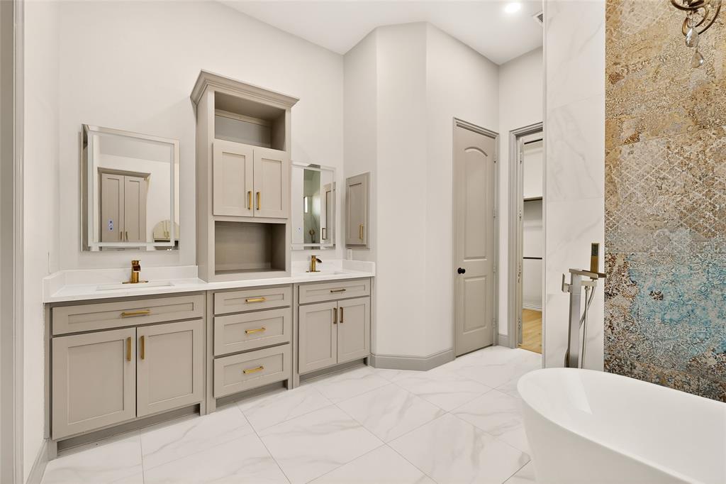 11048 Riney Court Frisco, TX 75035 - Photo 11 of 40 a spacious bathroom with a double vanity sink a mirror and a bathtub