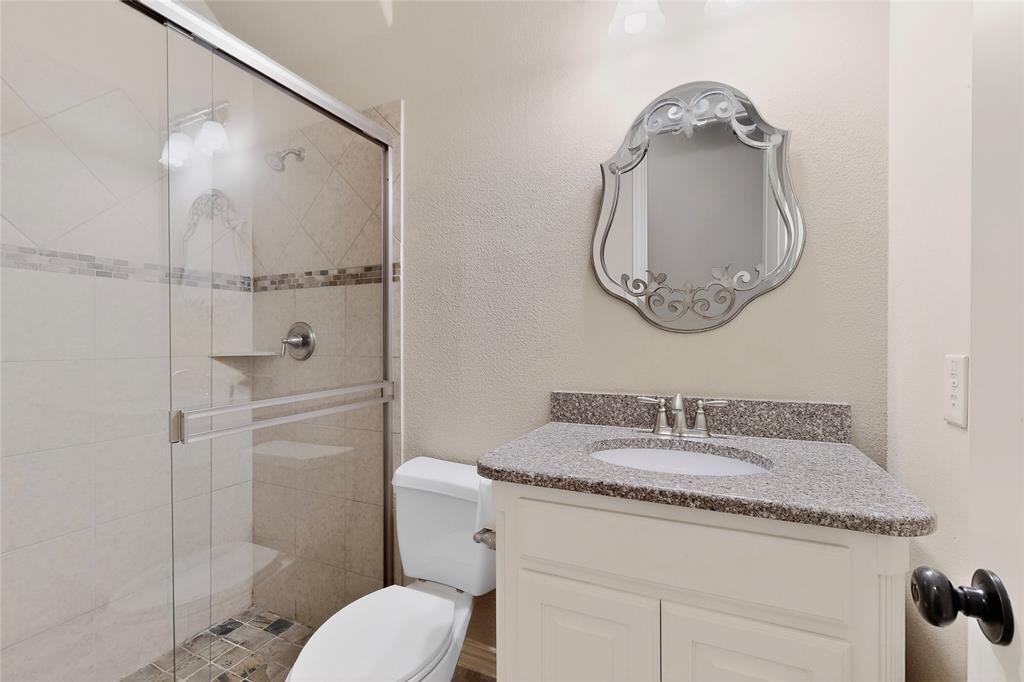 11048 Riney Court Frisco, TX 75035 - Photo 23 of 40 a bathroom with a granite countertop sink mirror vanity and toilet