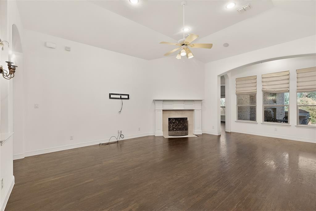11048 Riney Court Frisco, TX 75035 - Photo 6 of 40 an empty room with wooden floor fireplace and windows