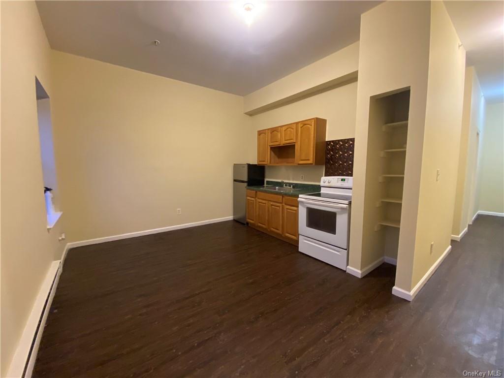 a kitchen with wooden floor and a microwave