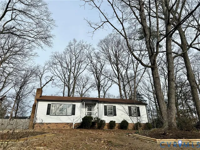 a view of empty room with wooden floor and fireplace
