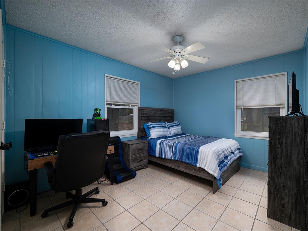 9663 Matise Street Tyler, TX 75706 - Photo 13 of 15 a bedroom with a bed and a chandelier