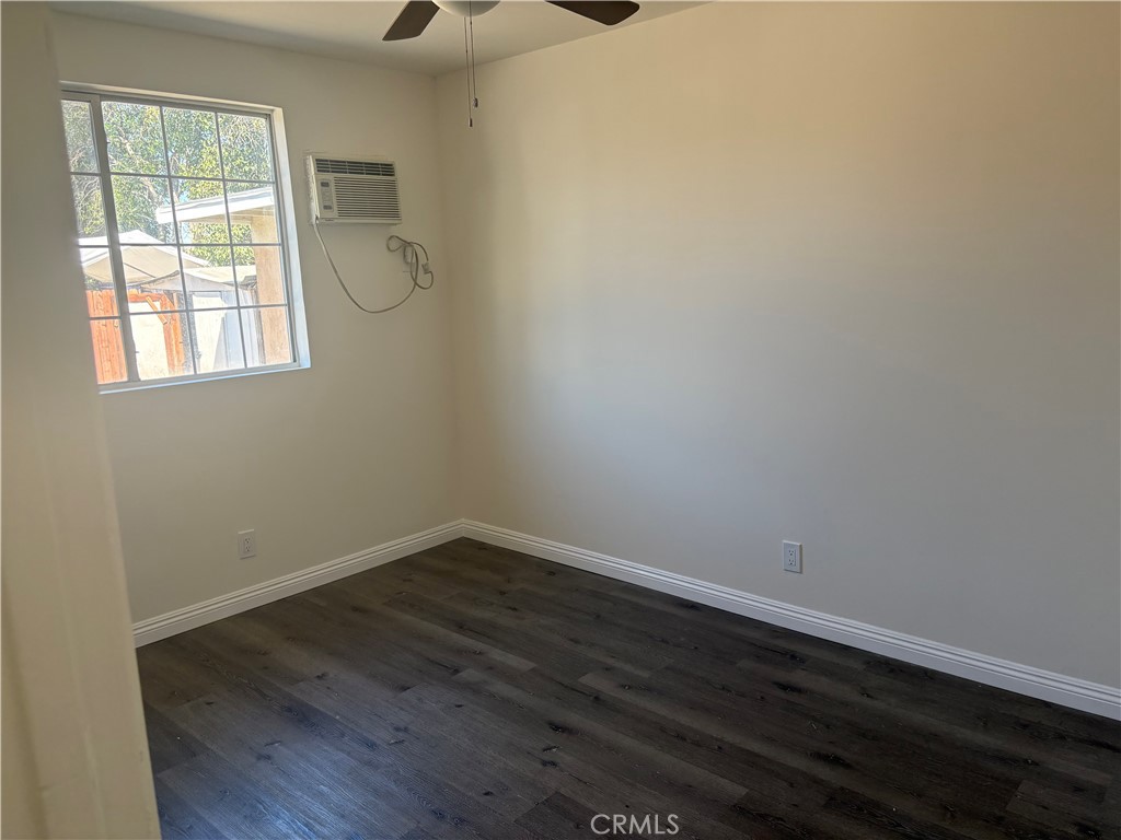 7563 Lincoln Avenue Riverside, CA 92504 - Photo 9 of 34 an empty room with wooden floor and windows