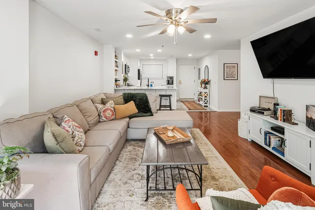 a living room with furniture kitchen view and a chandelier
