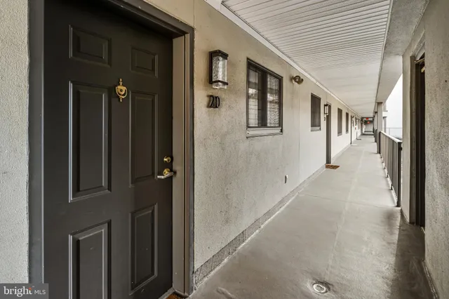 a view of a hallway with wooden floor and windows
