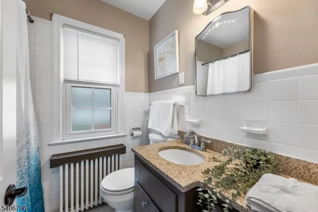 a bathroom with a granite countertop sink toilet and mirror