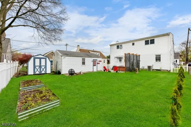 a view of a white house with a big yard and large trees