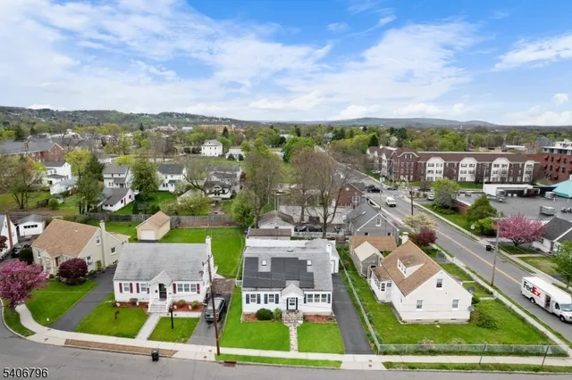 an aerial view of residential houses with outdoor space and ocean view