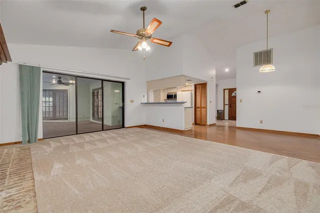 a view of empty room with a kitchen