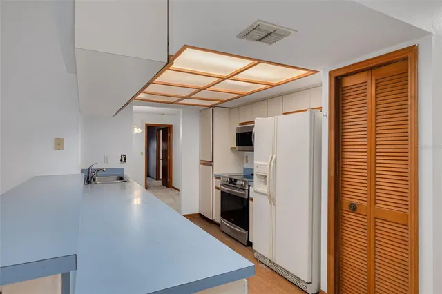 a kitchen view with stainless steel appliances a refrigerator and a stove top oven
