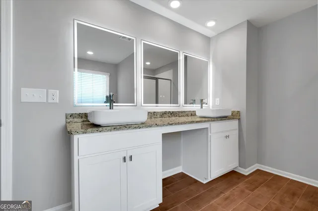 a bathroom with a granite countertop sink and a mirror