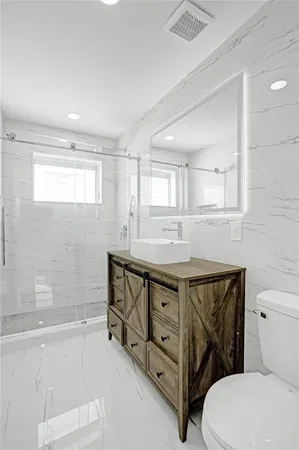 a view of a hallway with wooden floor and a refrigerator