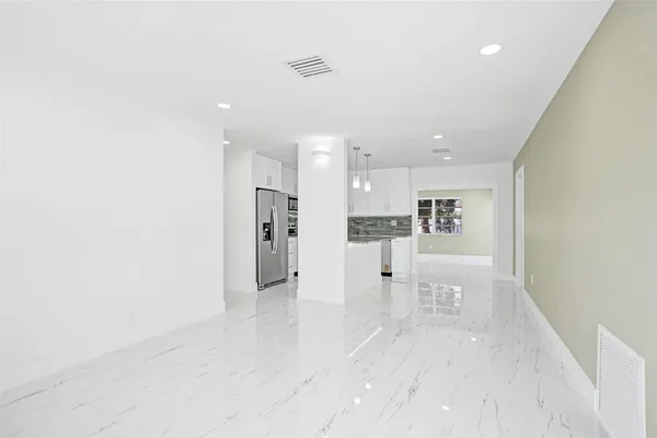 a view of kitchen with furniture and refrigerator
