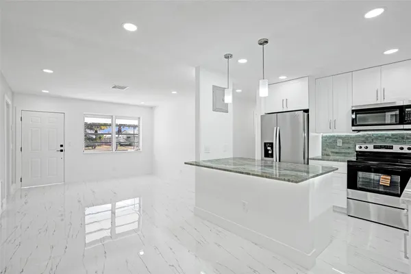 a kitchen with stainless steel appliances a refrigerator and a stove top oven