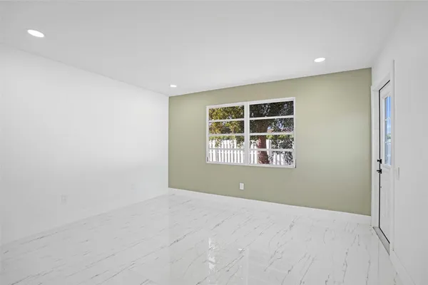 an empty room with window and wooden floor