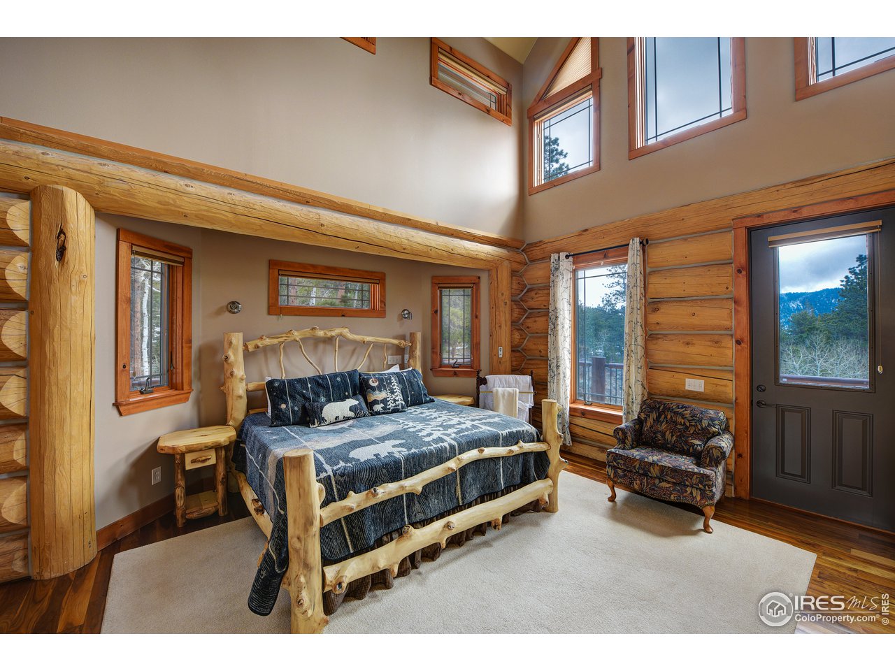500 Ridge Road Ward, CO 80481 - Photo 12 of 31 a bedroom with a bed and large windows