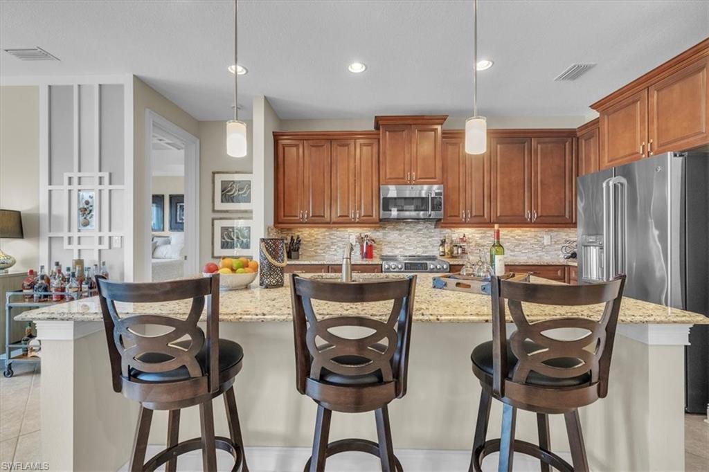 16480 Windsor Way Alva, FL 33920 - Photo 14 of 48 a kitchen with stainless steel appliances a table chairs and a refrigerator