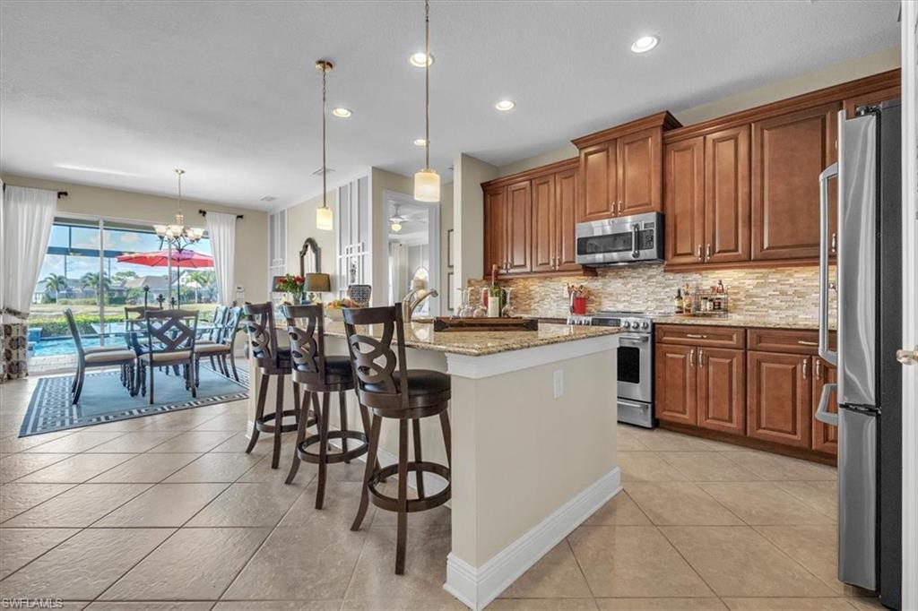 16480 Windsor Way Alva, FL 33920 - Photo 17 of 48 a kitchen with stainless steel appliances kitchen island granite countertop a table chairs sink and cabinets