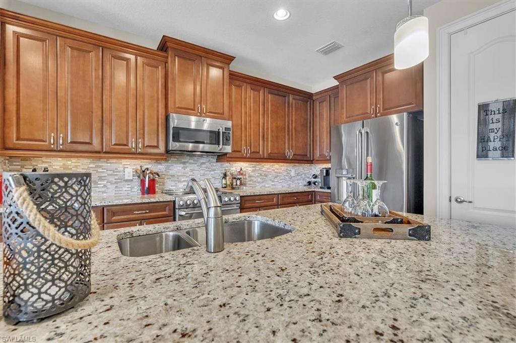 16480 Windsor Way Alva, FL 33920 - Photo 18 of 48 a kitchen with stainless steel appliances granite countertop a refrigerator sink and cabinets