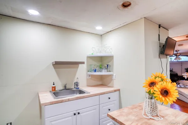 a view of kitchen island with stainless steel appliances sink refrigerator and window